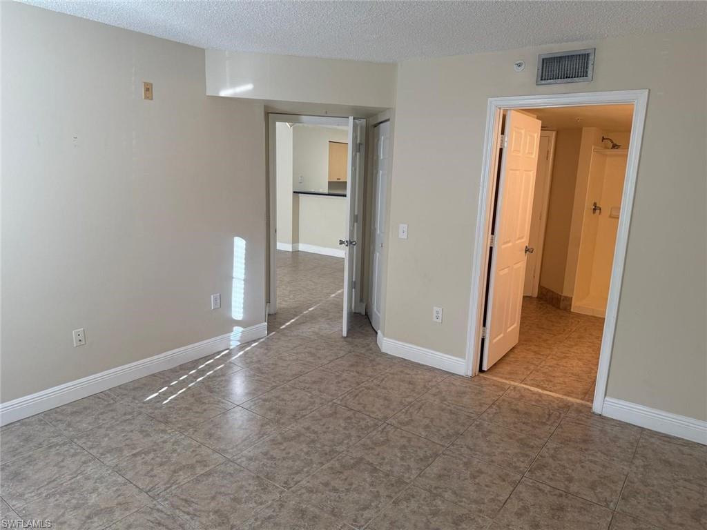 Unfurnished bedroom featuring a textured ceiling and light tile patterned flooring