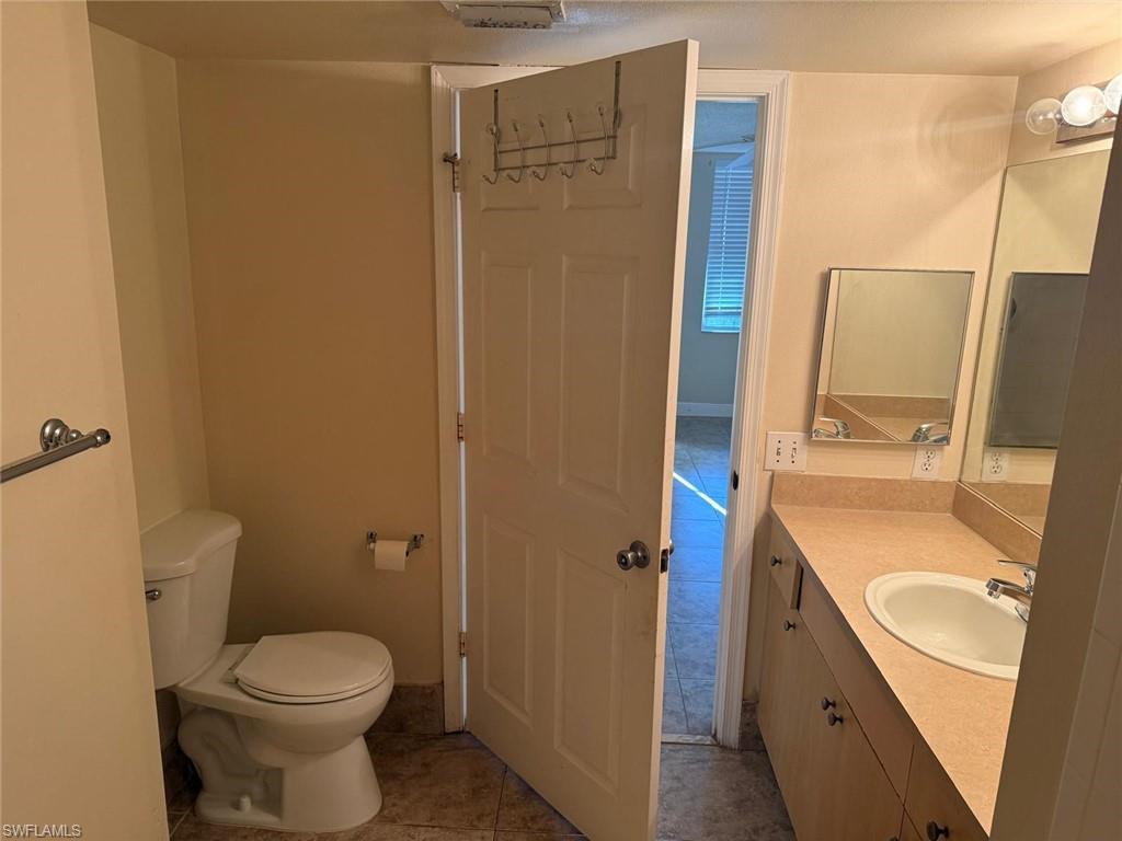 Half bath featuring vanity and light tile patterned floors