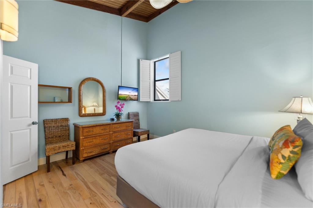Bedroom featuring light wood-type flooring and a wooden ceiling with exposed beams