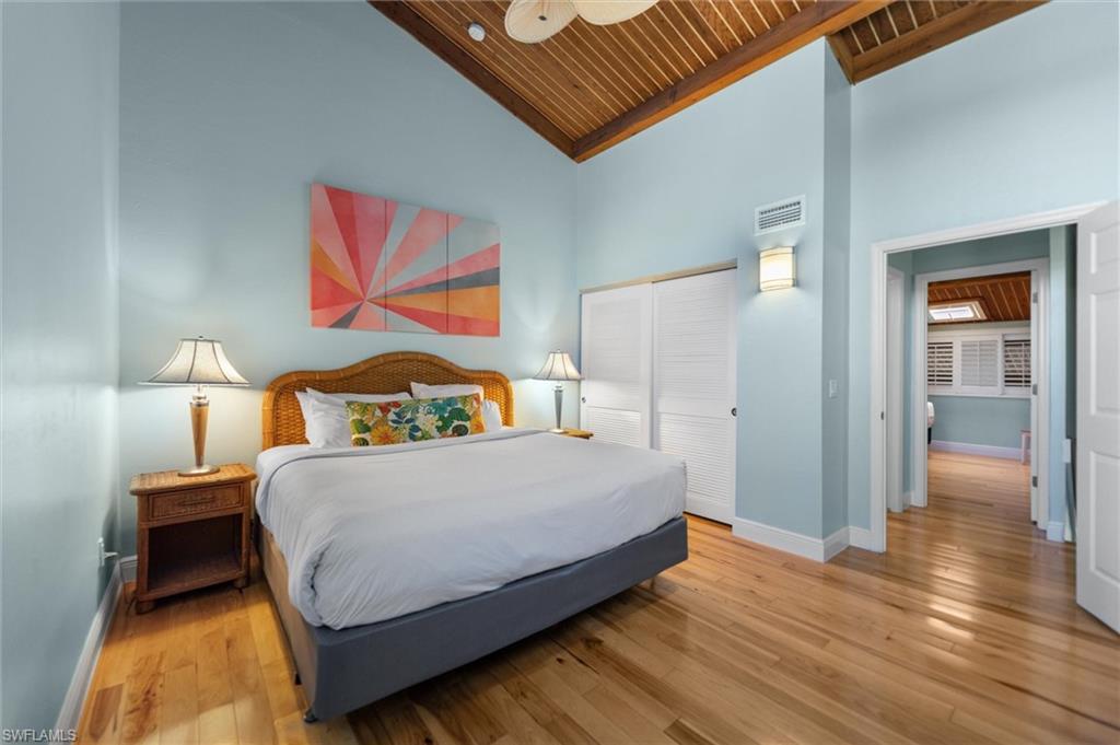 Bedroom with a vaulted wooden ceiling, light wood finished floors, a closet, and ceiling fan