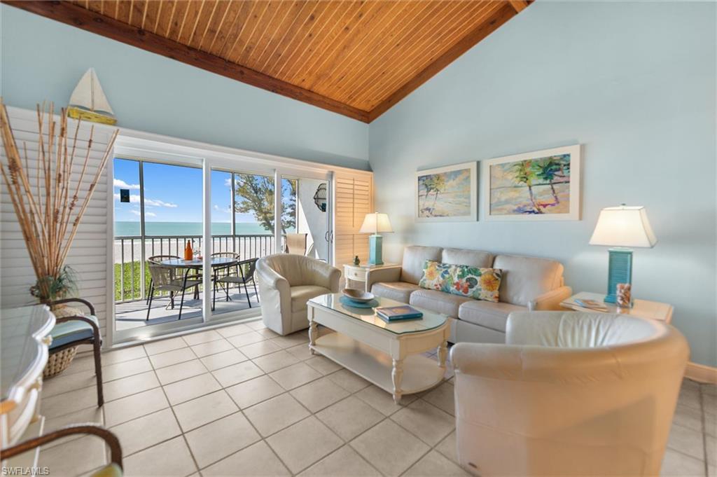 Living room with a water view, a vaulted wood ceiling, and light tile patterned floors