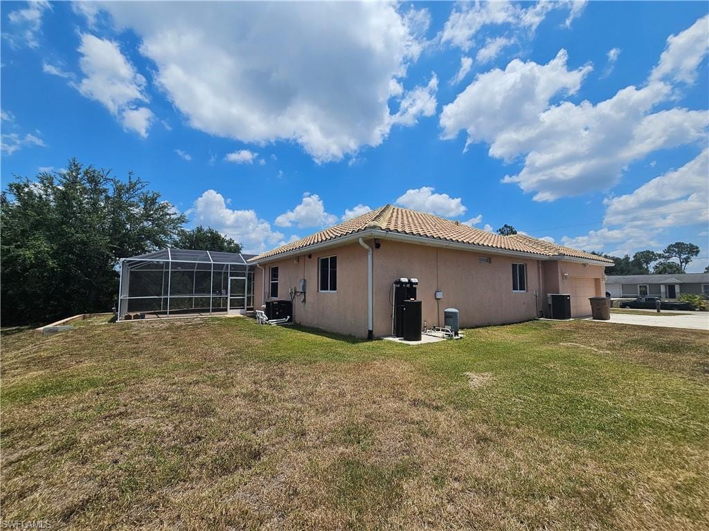 Rear view of property featuring a yard and a lanai