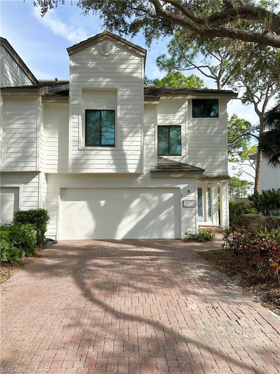 View of front facade with decorative driveway and an attached garage
