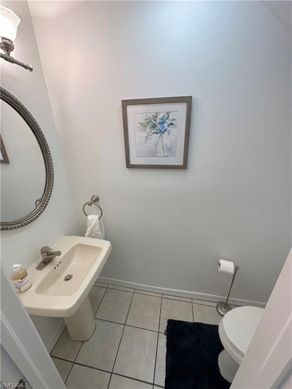 Bathroom with toilet and light tile patterned flooring