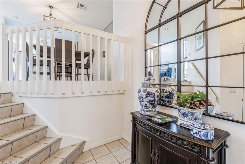Stairway with tile patterned floors and plenty of natural light