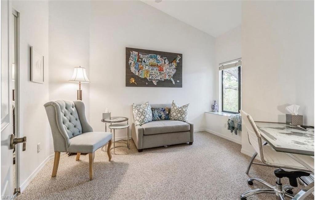 Home office with vaulted ceiling and light carpet