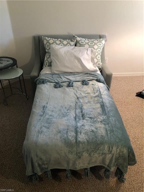 Bedroom featuring carpet and baseboards