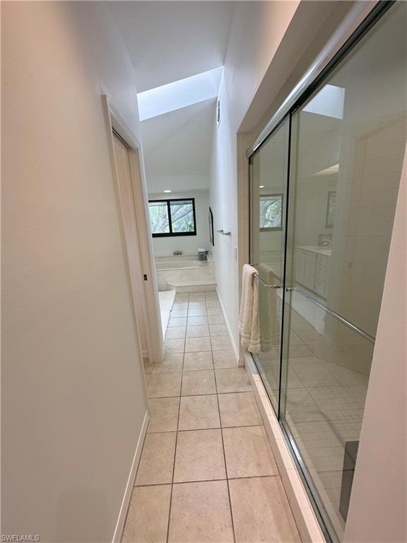 Hallway with light tile patterned floors and baseboards