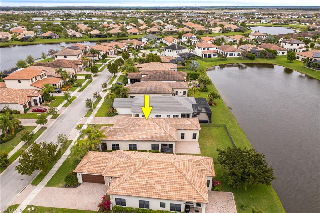 Aerial perspective of suburban area featuring a nearby body of water