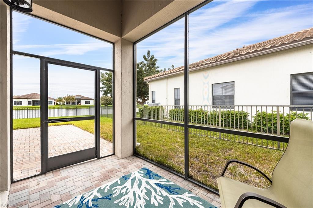 Sunroom featuring a water view and a residential view