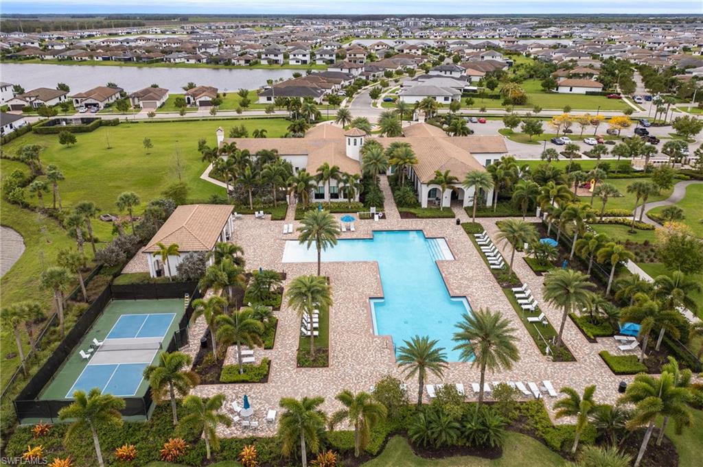 Aerial perspective of suburban area with a nearby body of water and a pool area