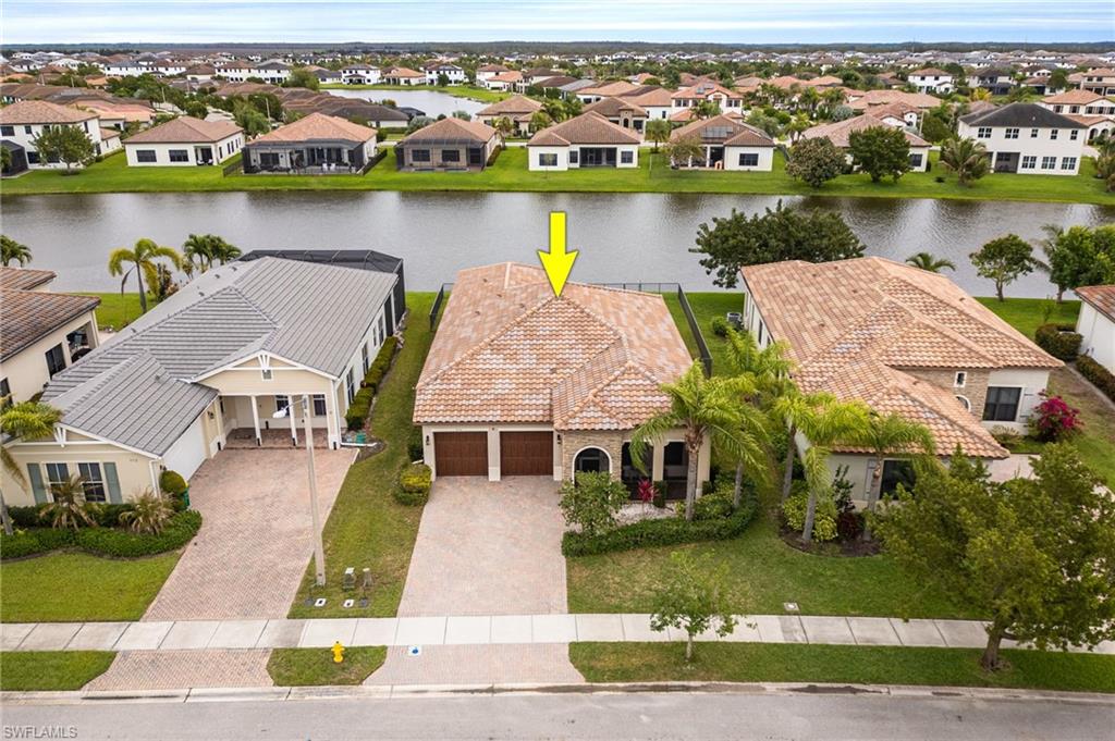 Aerial perspective of suburban area featuring a nearby body of water