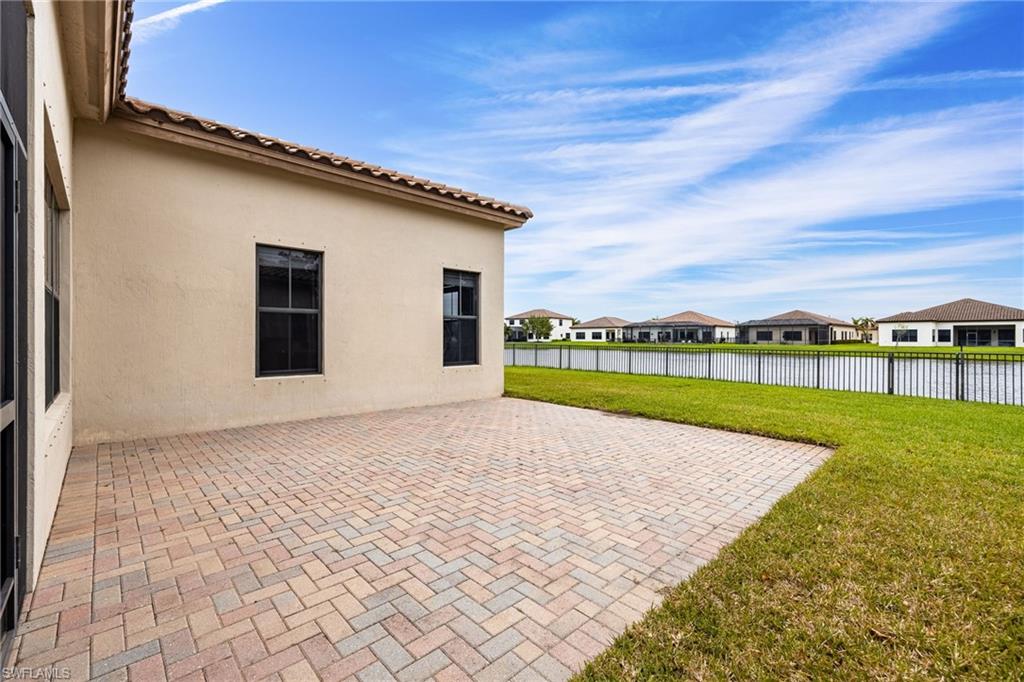 Fenced backyard with a patio area, a residential view, and a water view