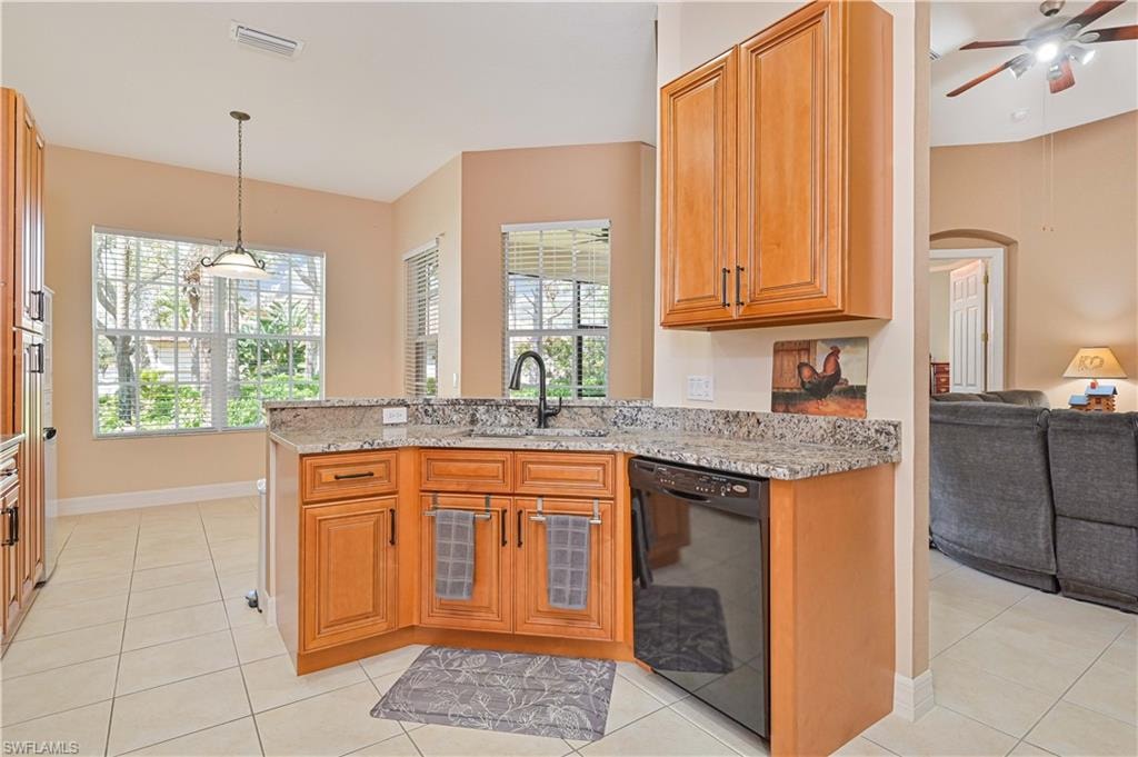 Kitchen featuring light stone countertops, black dishwasher, a ceiling fan, a peninsula, and wood finish cabinetry