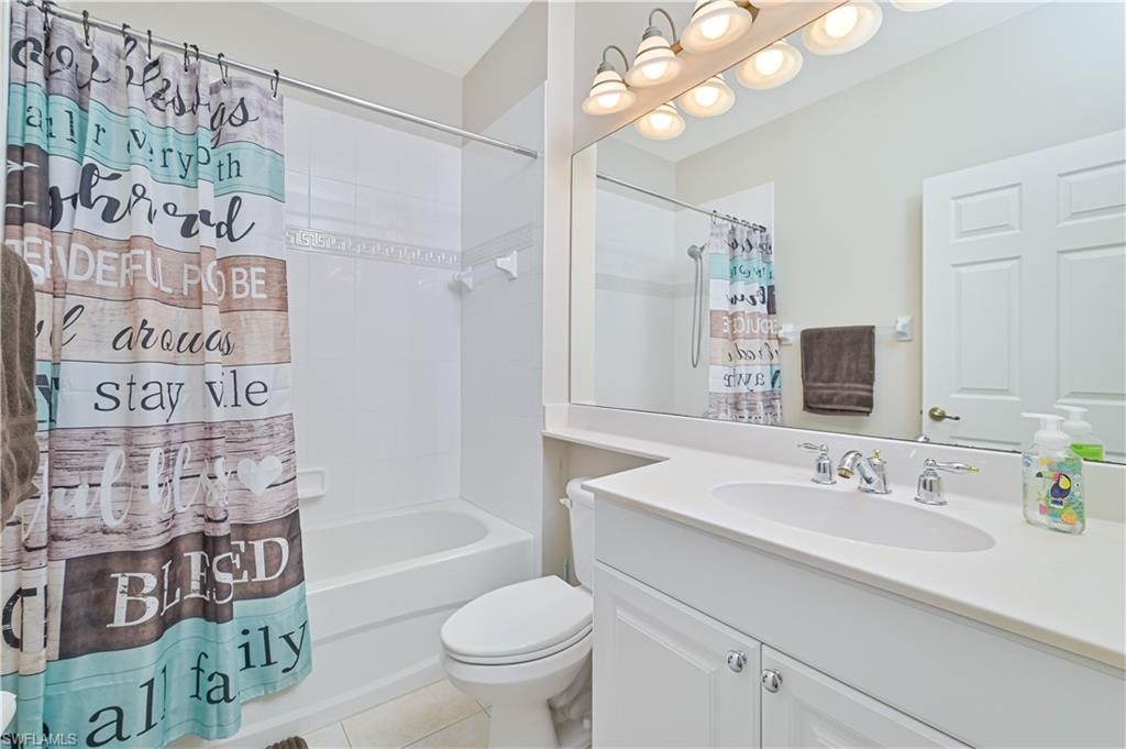 Bathroom featuring vanity, shower / bath combo, and light tile patterned floors