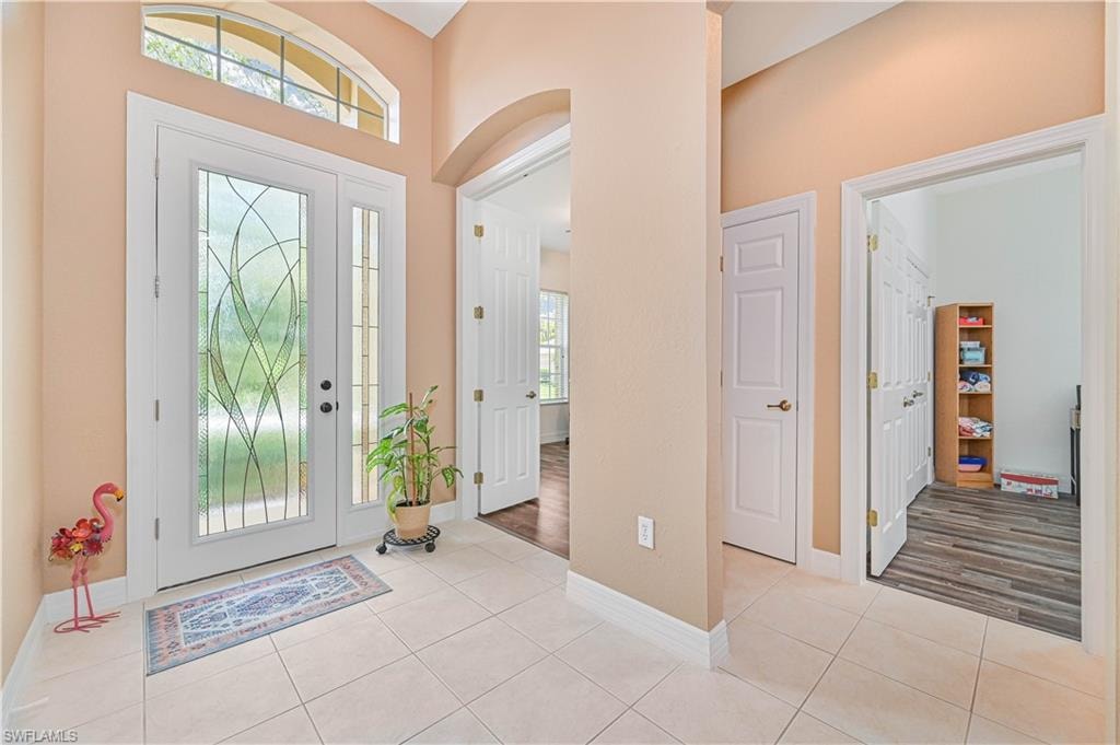 Foyer featuring arched walkways and light tile patterned floors