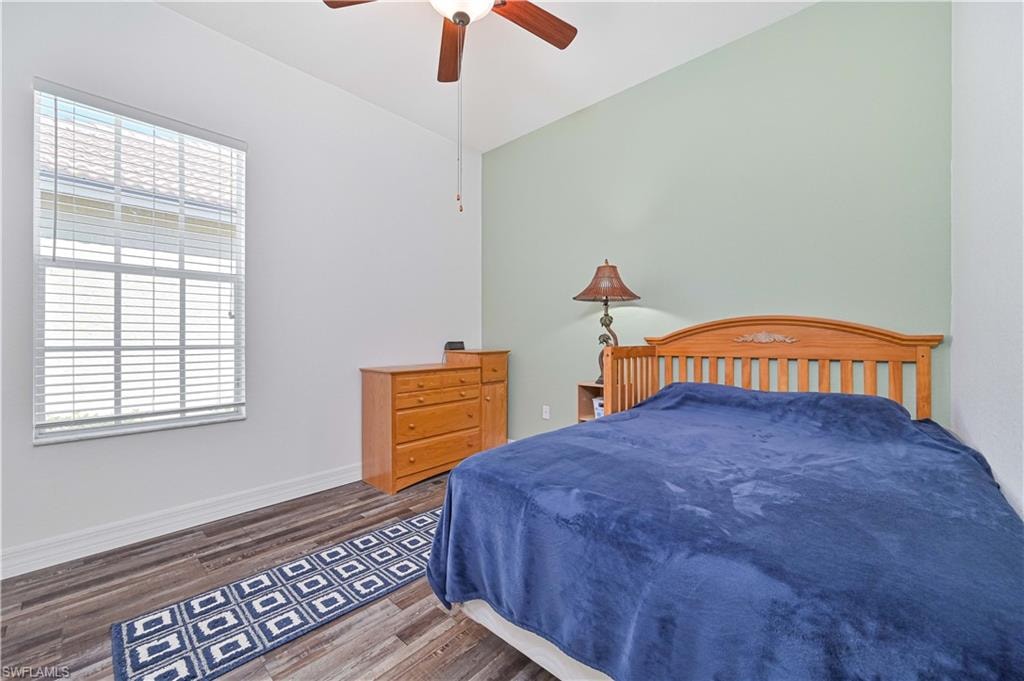 Bedroom featuring wood finished floors, a ceiling fan, and lofted ceiling