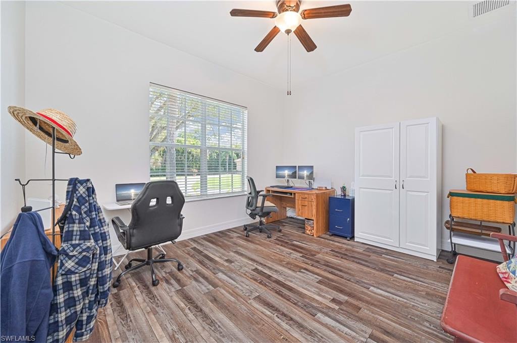 Office area with dark wood-style flooring and a ceiling fan