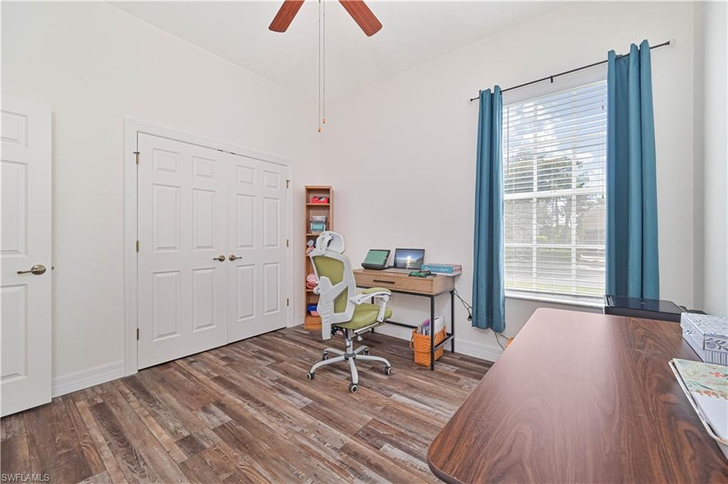 Office space with dark wood finished floors, a ceiling fan, and lofted ceiling