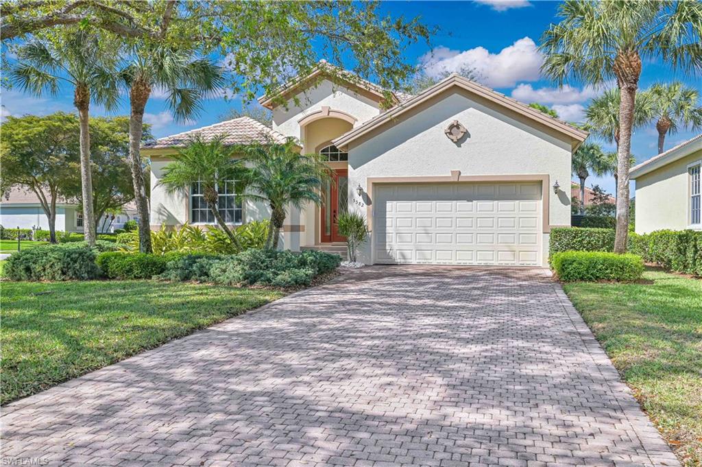 Mediterranean / spanish-style home featuring a front lawn, an attached garage, decorative driveway, and stucco siding