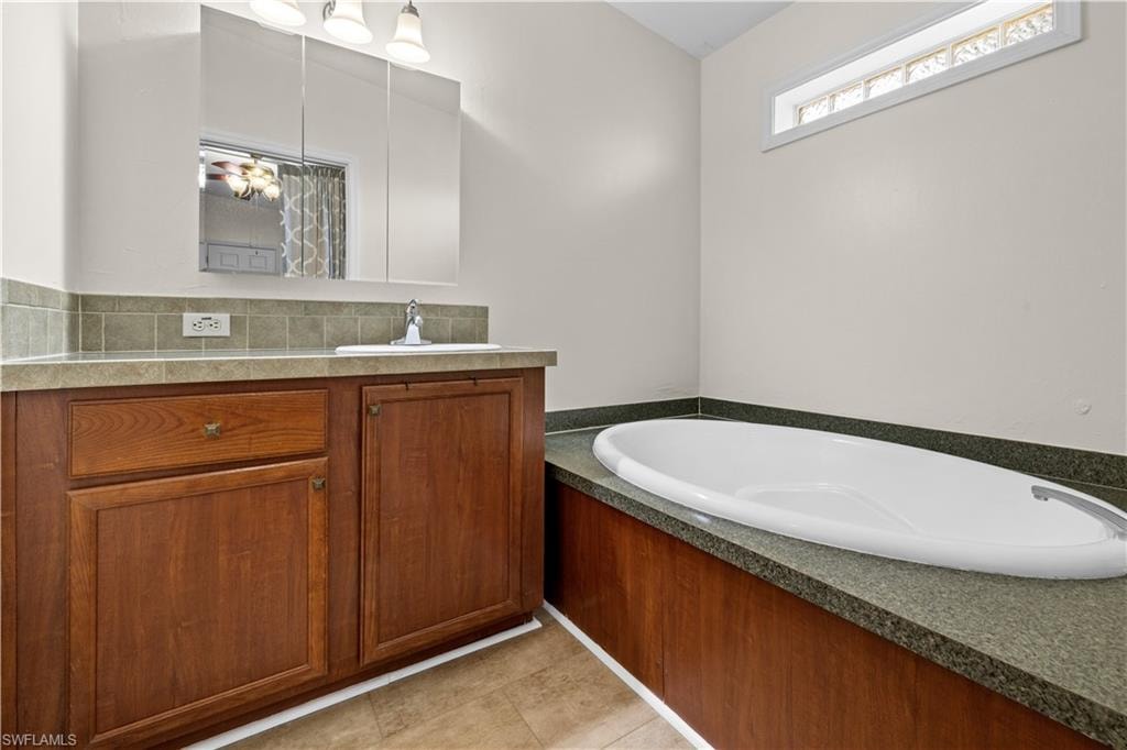 Full Master bathroom featuring vanity, a bath, and decorative backsplash