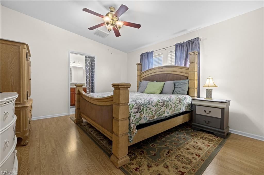 Master Bedroom featuring vaulted ceiling, light wood-style flooring, ceiling fan, and ensuite bathroom