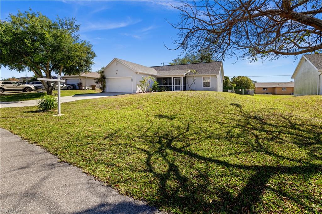 Ranch-style house with an attached garage, stucco siding, concrete driveway, and a front lawn