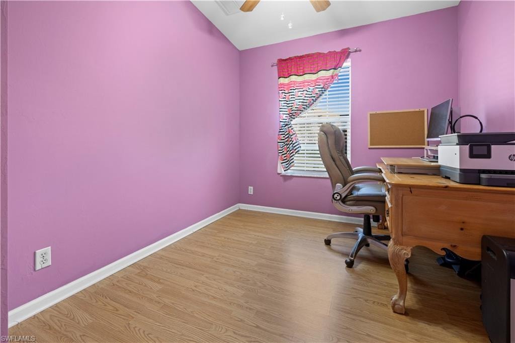 Home office/ bedroom featuring light wood-style flooring, a ceiling fan, and lofted ceiling