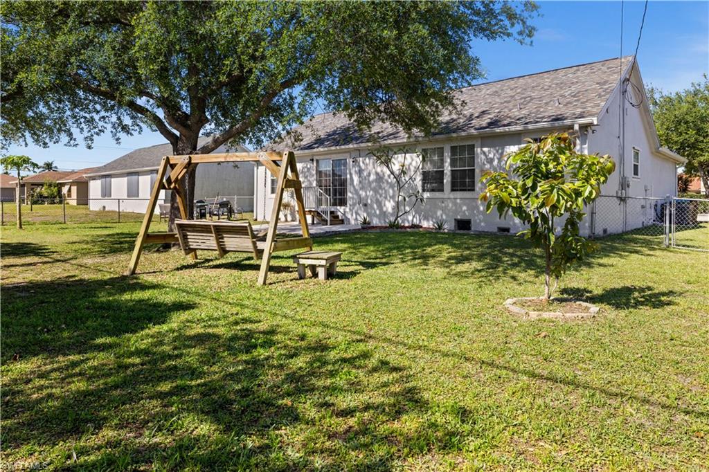 Rear view of property with a fenced backyard and a shingled roof