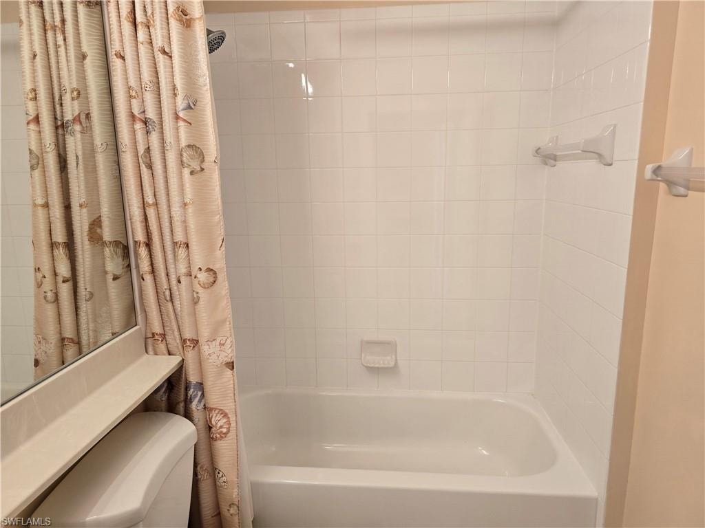 Full bathroom featuring shower / tub combo with curtain and toilet