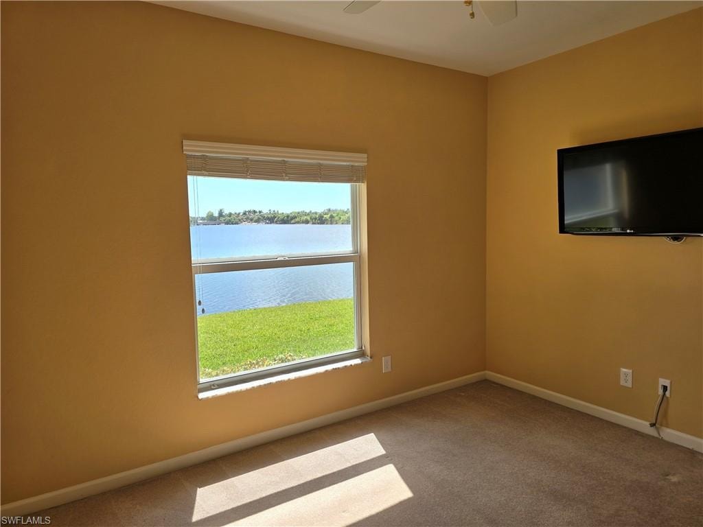 2nd bedroom room featuring light carpet and ceiling fan and lake view