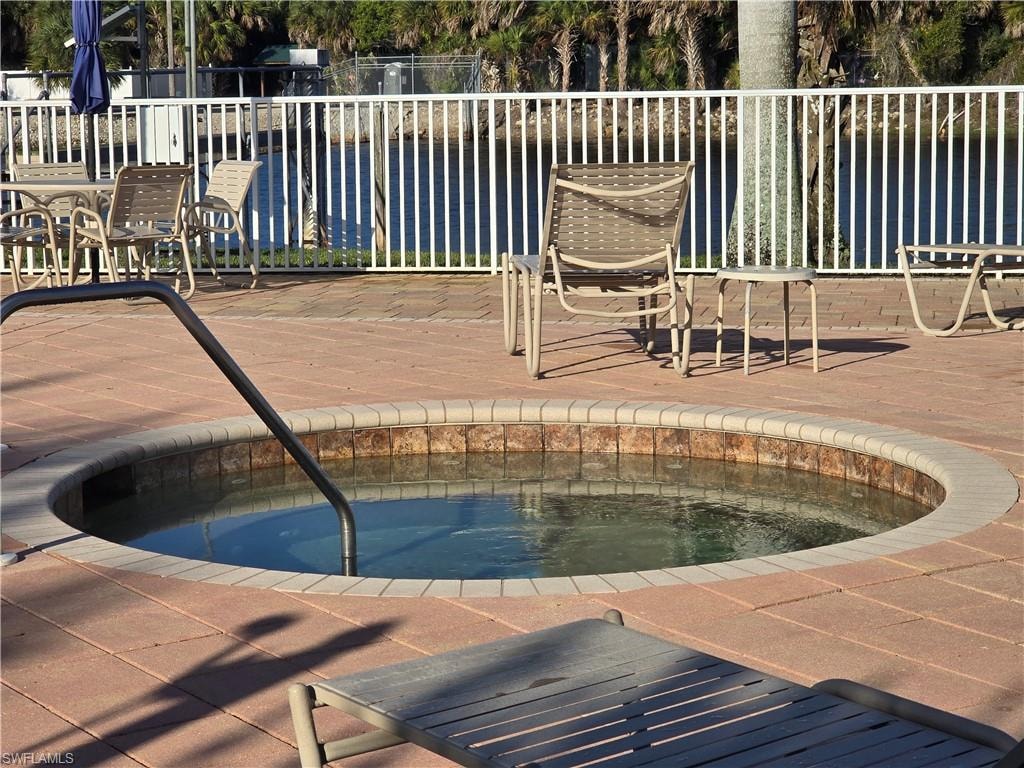 View of pool with a hot tub
