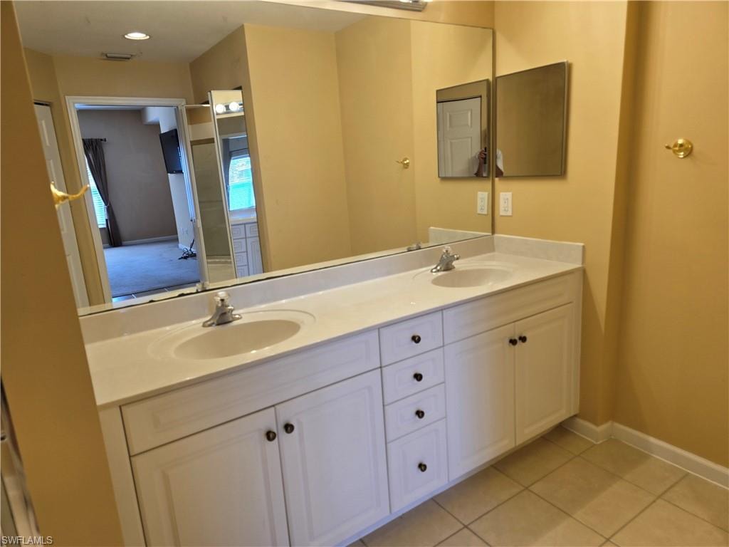 Bathroom featuring double vanity and light tile patterned floors