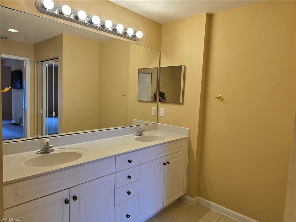 Master bathroom features double vanity and light tile patterned floors