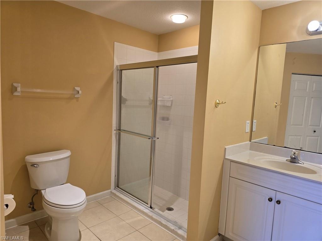 Bathroom with vanity, a shower stall, and light tile patterned flooring