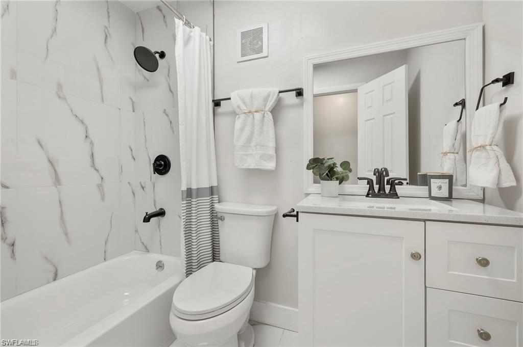 Bathroom with vanity and shower / bath combination with curtain