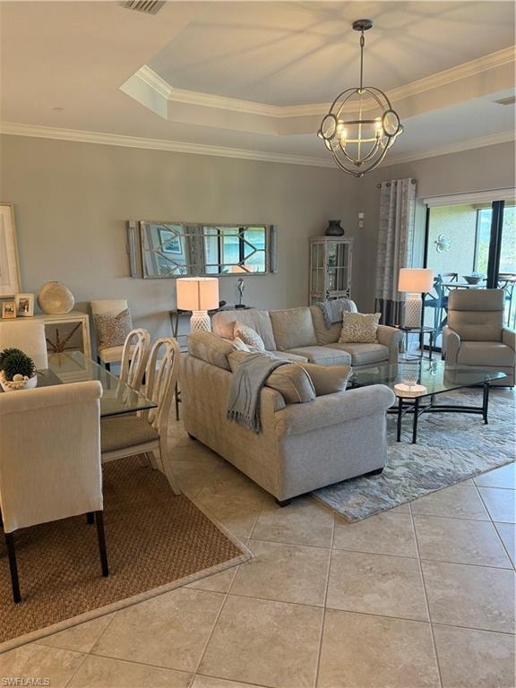 Living room featuring hanging lights, crown molding, tile patterned floors, and a raised ceiling