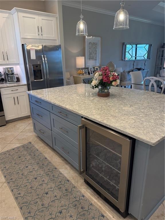 Kitchen featuring wine cooler, two tone cabinetry, light stone countertops, fridge, and crown molding