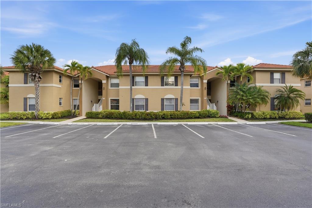 View of apartment building / complex with uncovered parking