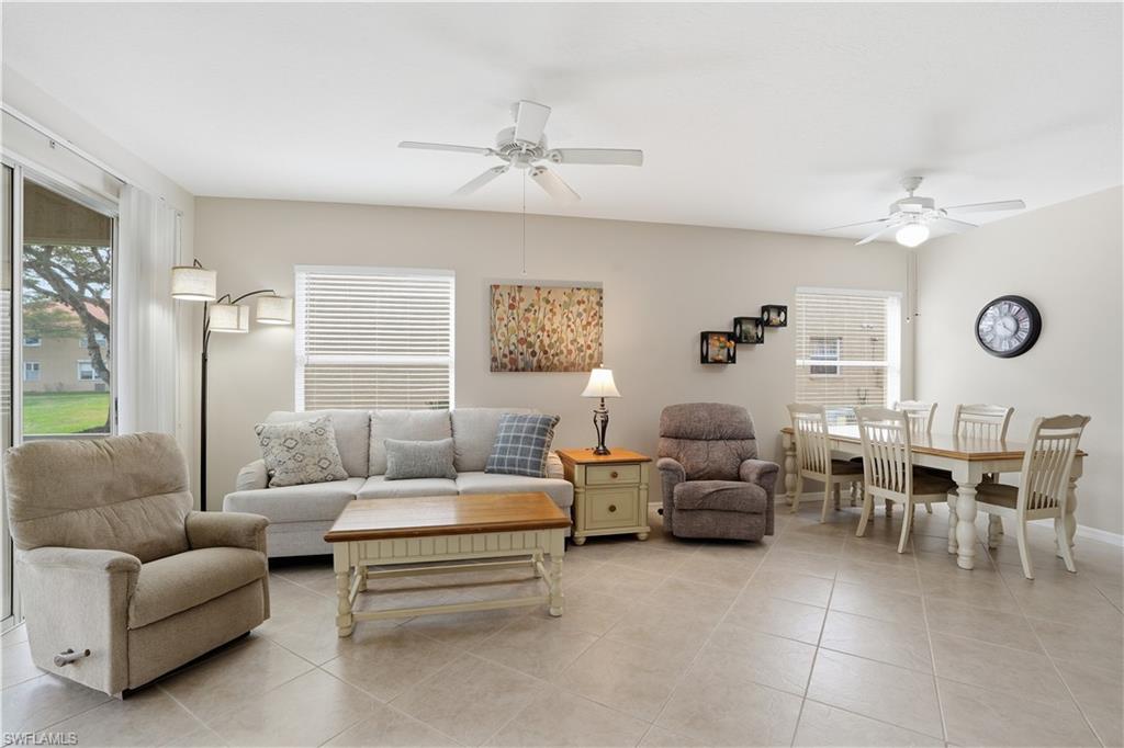 Living area with a ceiling fan, plenty of natural light, and light tile patterned floors