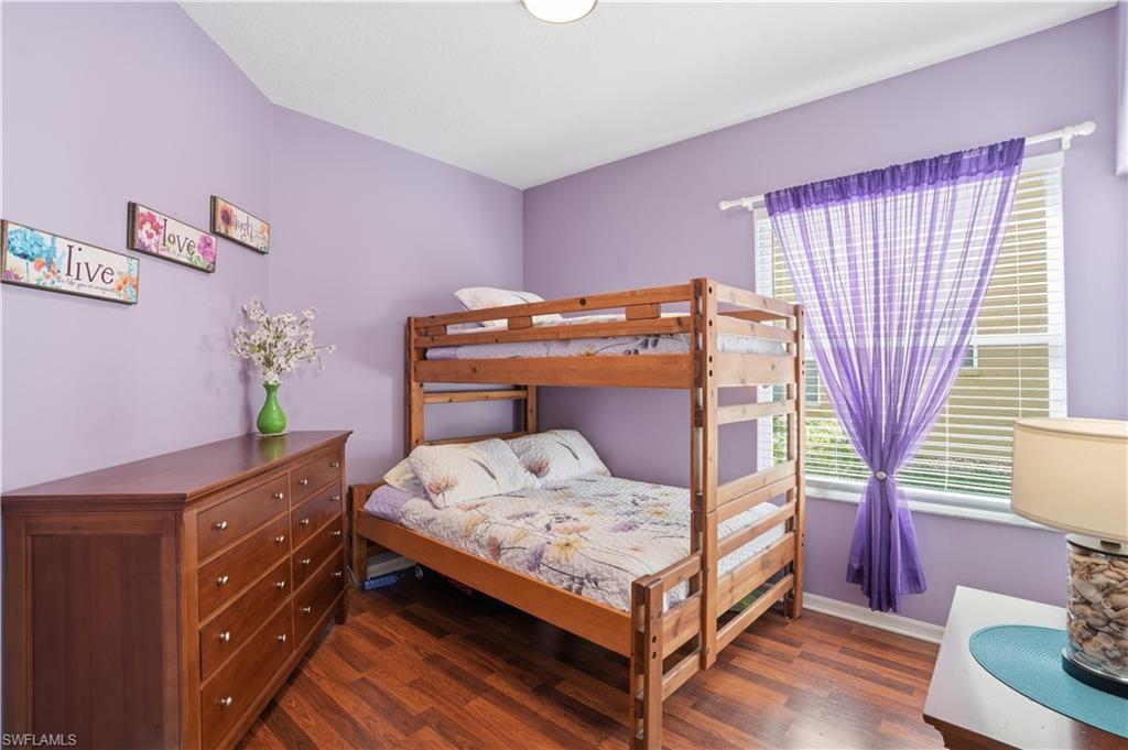 Bedroom featuring dark wood finished floors and baseboards