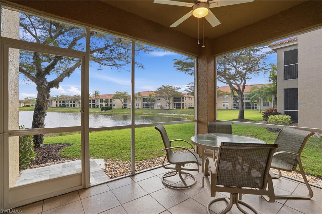 Sunroom featuring tile patterned flooring and a water view
