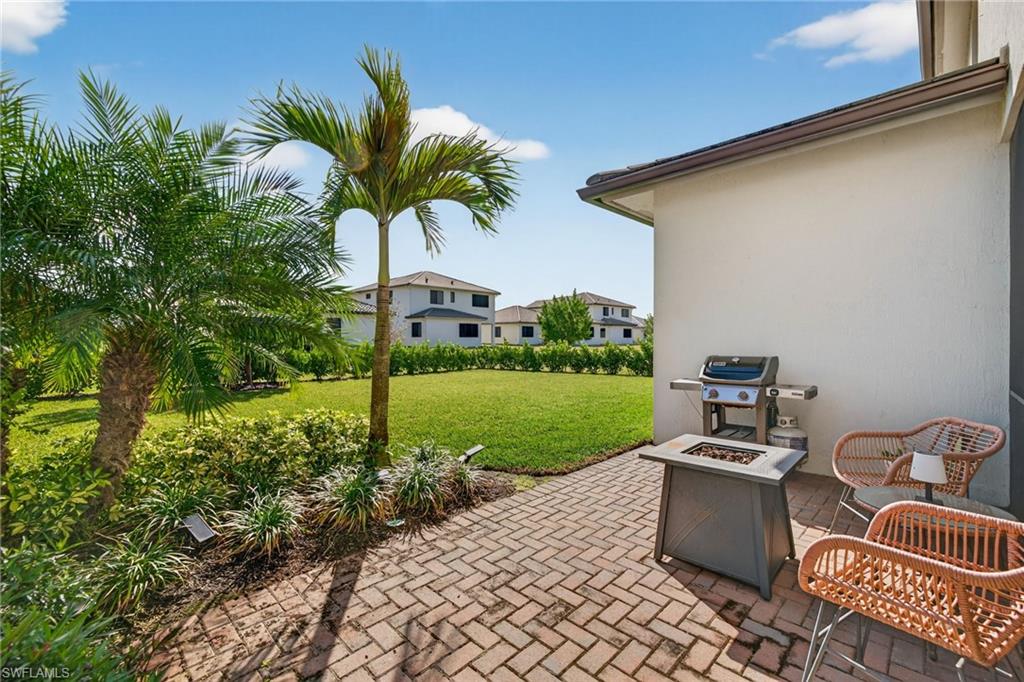 View of patio with a fire pit and a grill