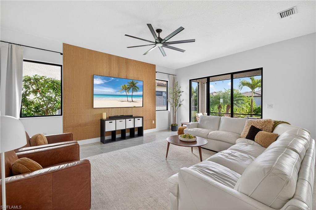 Living area featuring ceiling fan and an accent wall