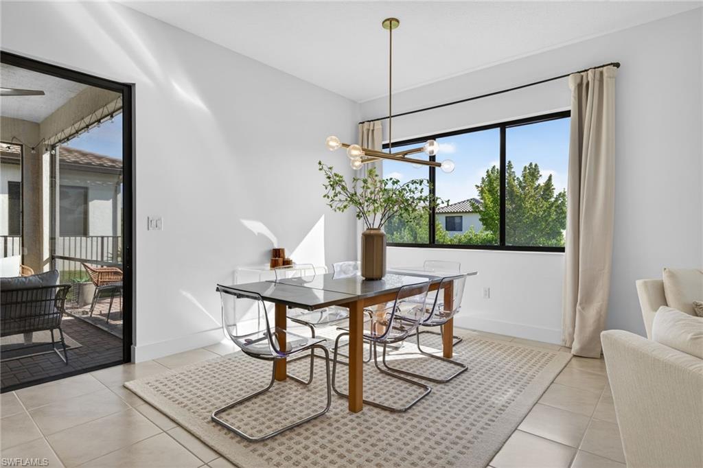 Dining room with healthy amount of natural light, light tile patterned floors, and hanging lights