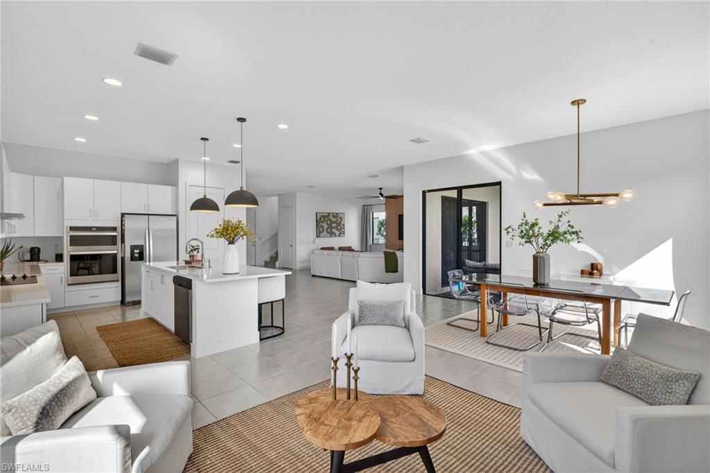 Living room featuring hanging lights, ceiling fan, and light tile patterned floors