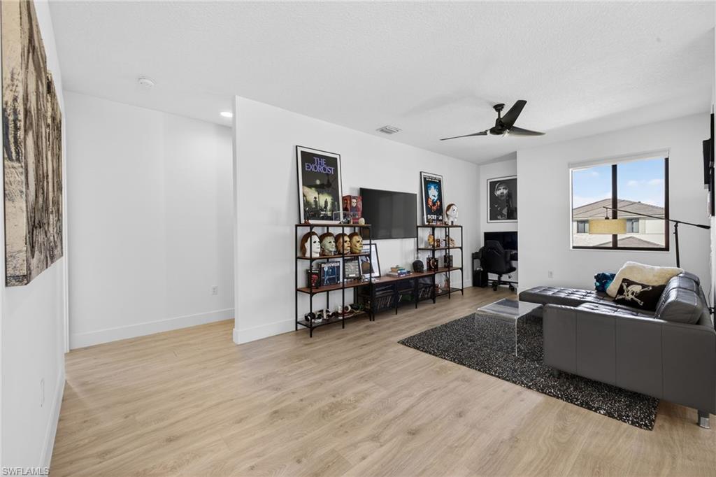 Living room with light wood finished floors and a ceiling fan