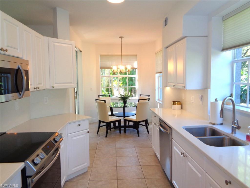 Kitchen featuring stainless steel appliances, white cabinets, and light tile patterned floors