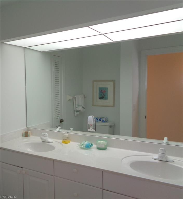 Full bath featuring double vanity and a closet