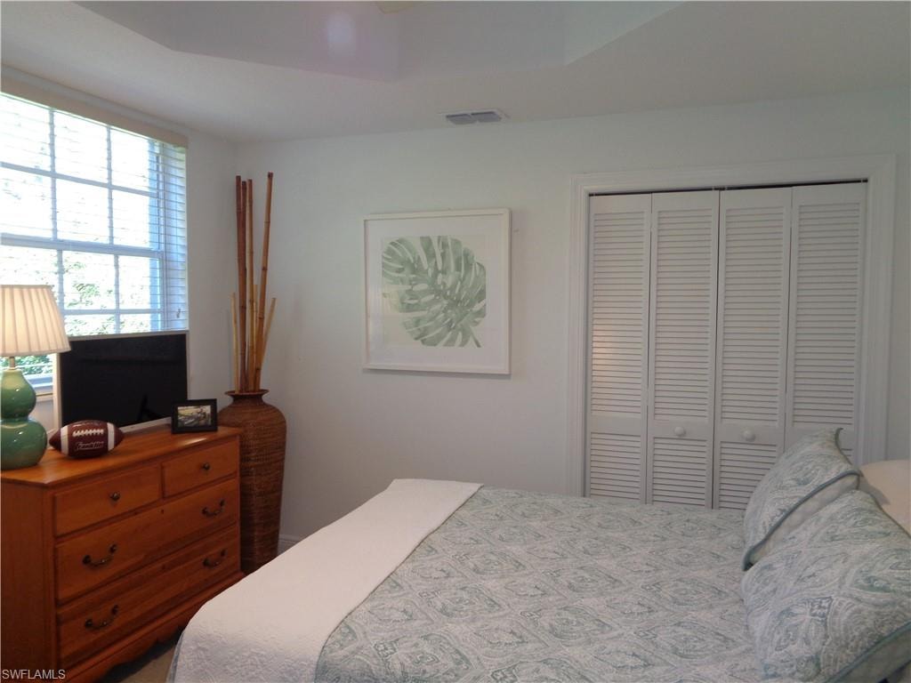 Bedroom featuring a closet, ceiling fan, and a raised ceiling